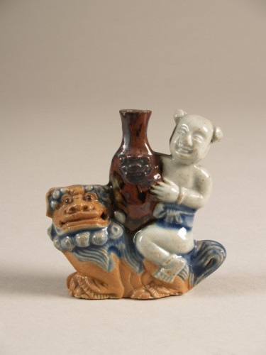 Waterdruppelaar in de vorm van een qilin met op de rug een jongen die een vaas vasthoudt